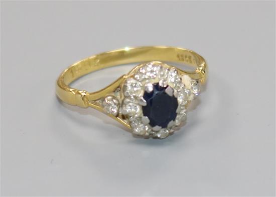 An 18ct gold and platinum, sapphire and diamond cluster ring, size O.